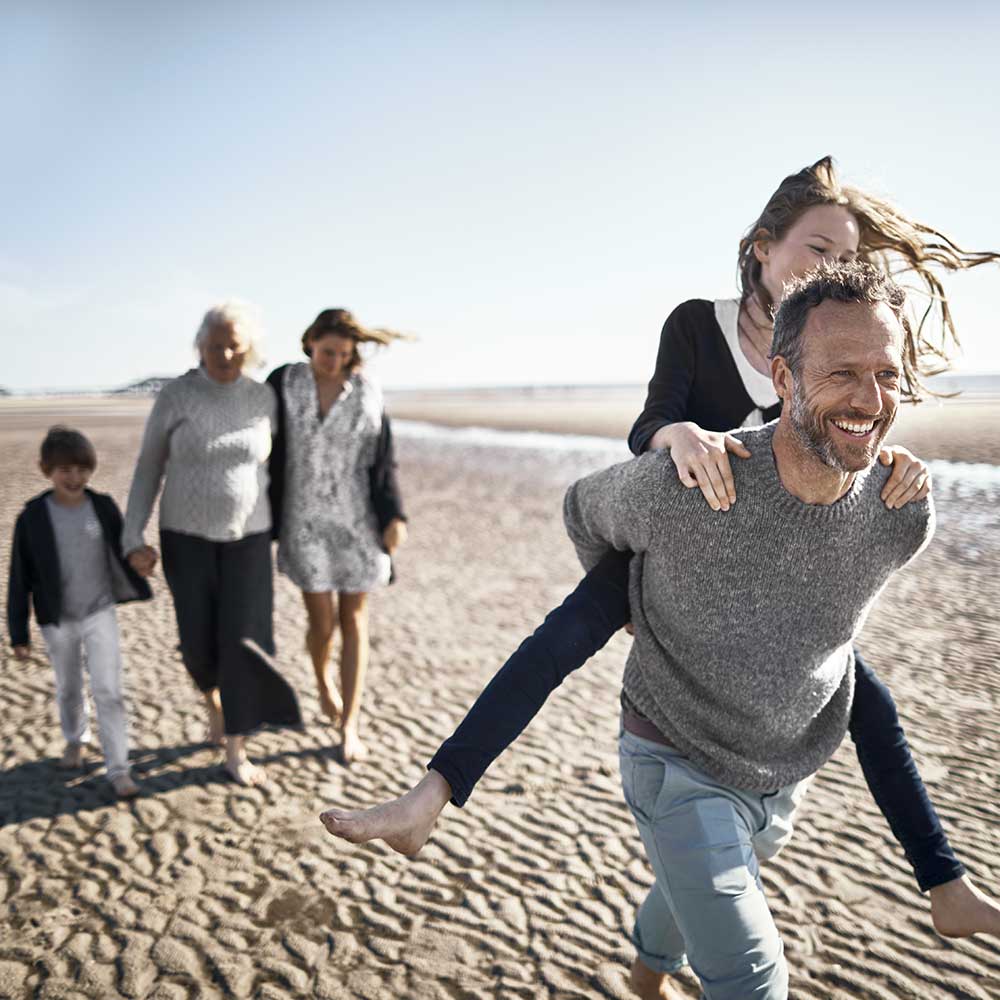 Familj som promenerar på en strand