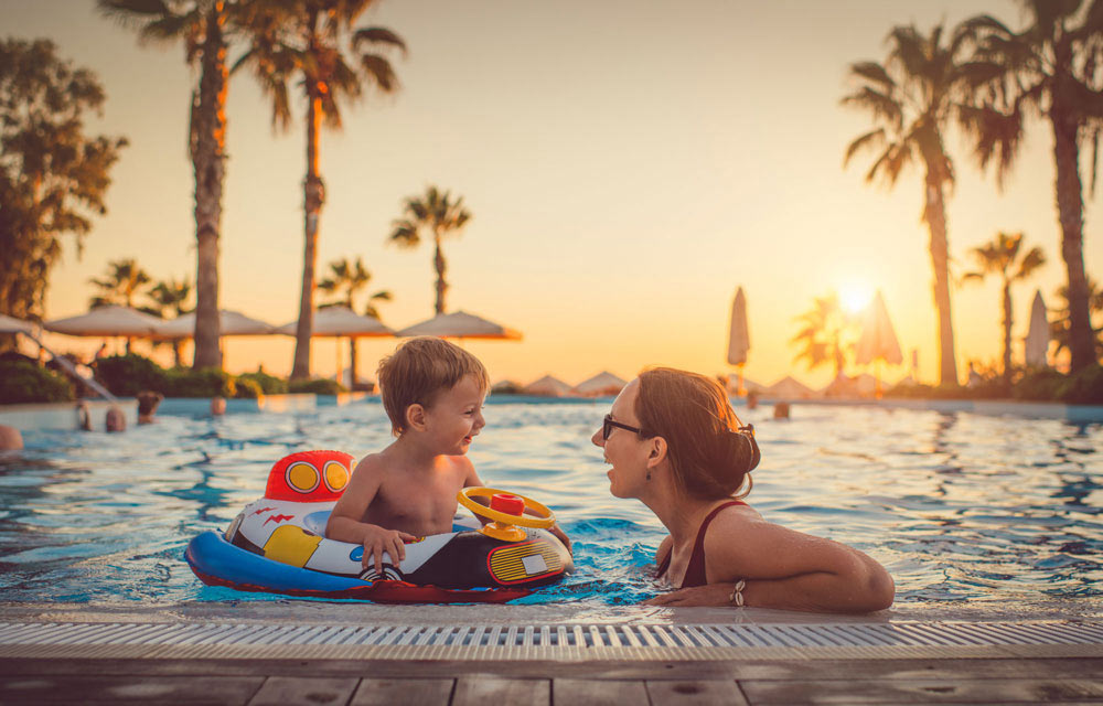 En mamma och ett barn badar i en pool